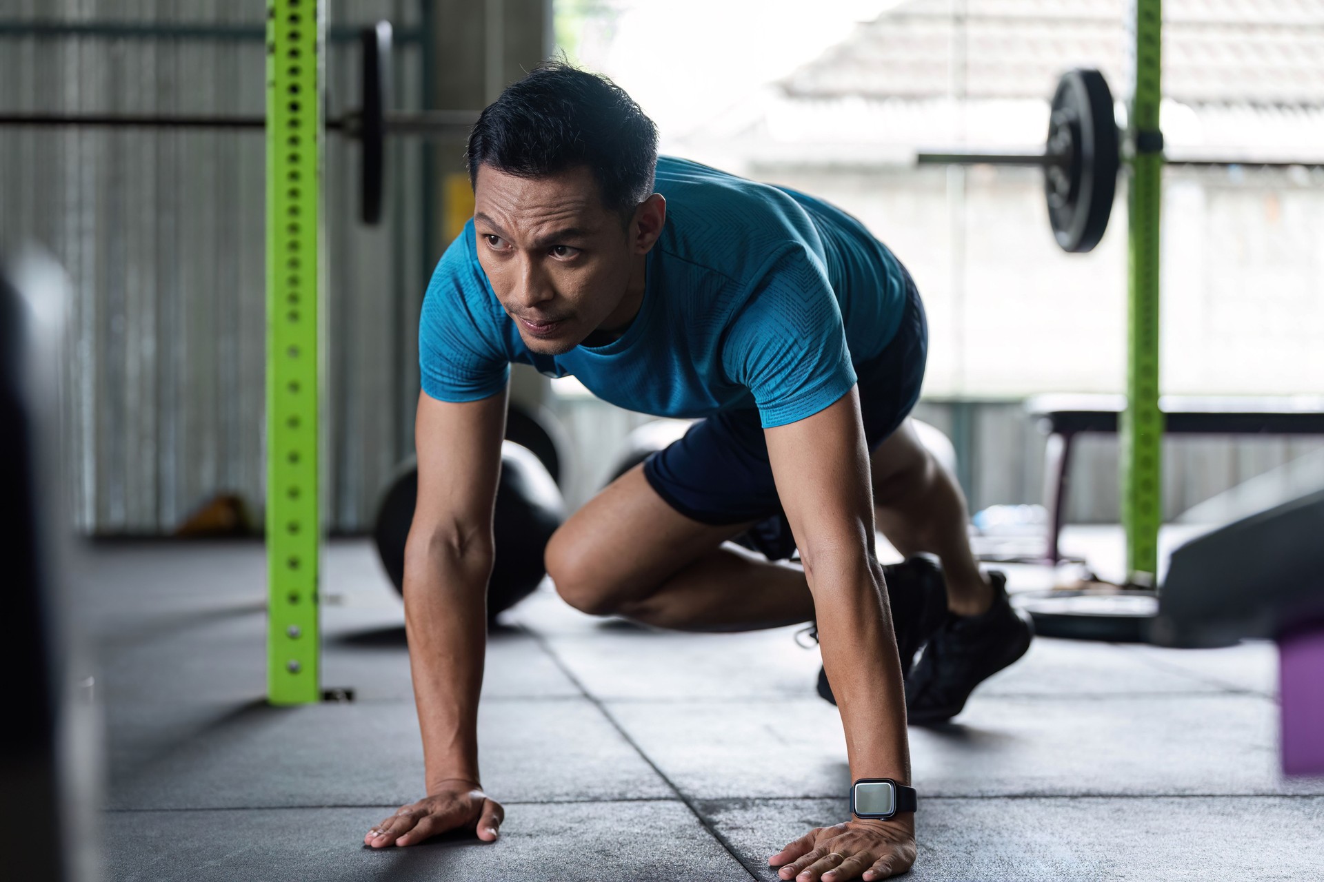 Fitness Cardio Workout. Man doing mountain climbers in gym.