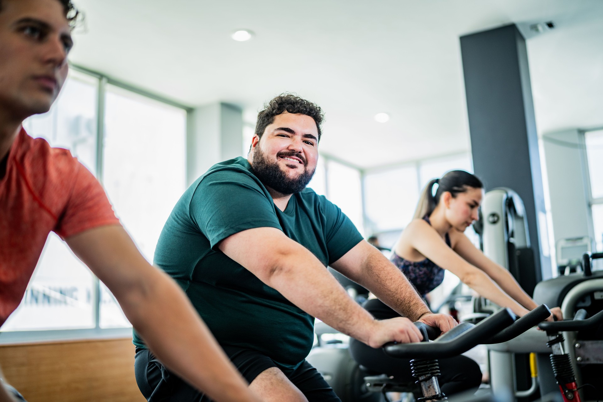 Portrait of mid adult man on exercise bike at gym