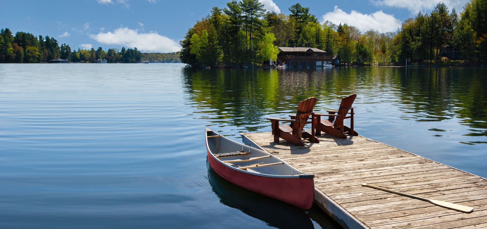 Two Adirondack chairs on a wooden dock